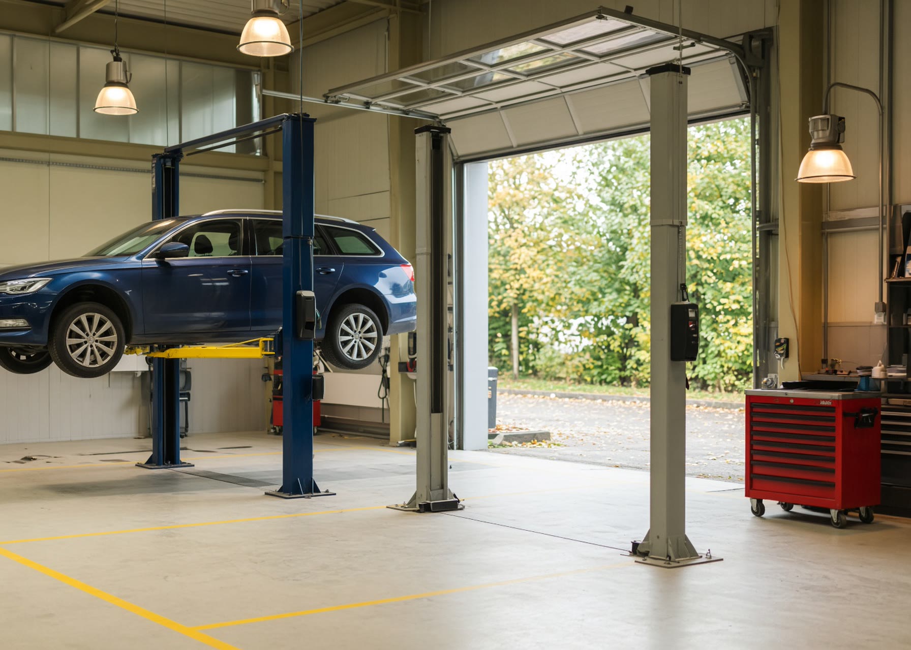 Ein Auto rollt von der senkenden Hebebühne in der Werkstatt des Autohauses Mosig.